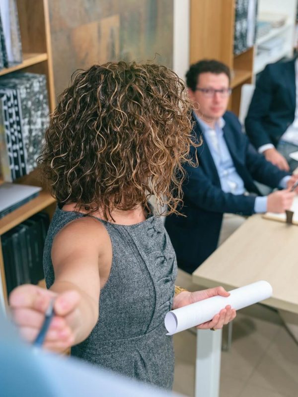 female-coach-explaining-project-to-business-team-in-headquarters.jpg